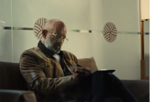 Senior male patient completing paperwork in a medical office waiting room