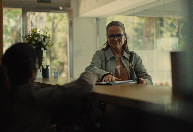 Older female patient engaged in pre-visit documentation with clipboard in hand