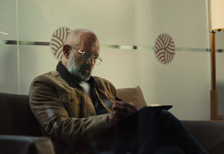 Senior male patient completing paperwork in a medical office waiting room